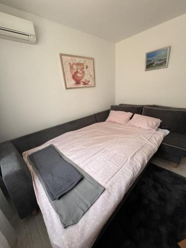 a bedroom with a bed with a gray blanket at Sweet Escape Varna in Varna City