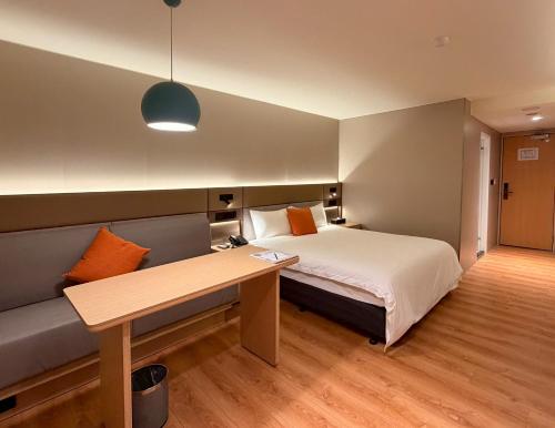 a hotel room with a bed and a desk at 丰居中壢 Via Hotel Zhongli in Zhongli