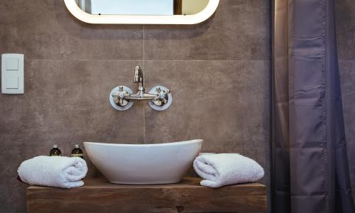 a bathroom with a white sink and a mirror at artlodge TinyHouses in Treffen