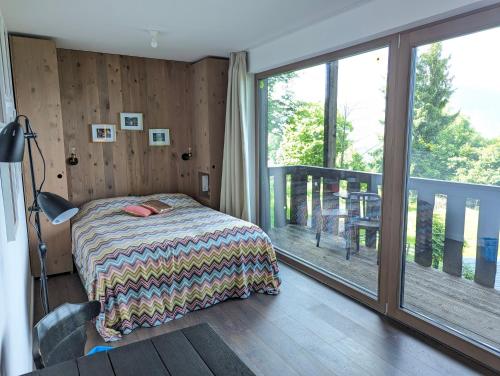 a bedroom with a bed and a balcony at artlodge TinyHouses in Treffen
