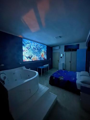 a bedroom with a bed and a large screen television at Suite al mare in Taranto