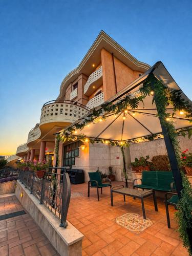 a patio with benches and an umbrella in front of a building at Hotel Valle Rossa in San Giovanni Rotondo