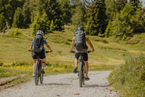 two people riding bikes down a dirt road at Obergasserhof in Rodengo