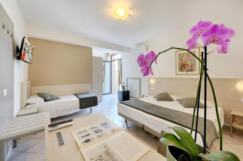 a hotel room with two beds and a table at Hotel Castello in Sovicille