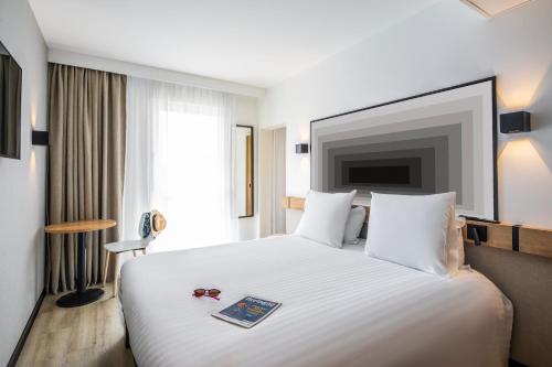 a hotel room with a white bed and a tv at ibis Brest Centre in Brest