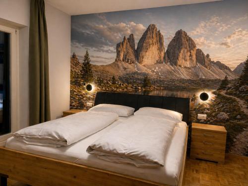 a bedroom with a bed with a mountain mural on the wall at Villa Erika - NEW Luxury Alpine Apartments from December 2026 in Sesto