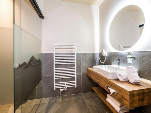 a bathroom with a sink and a mirror at Hotel Goldene Rose in Reutte
