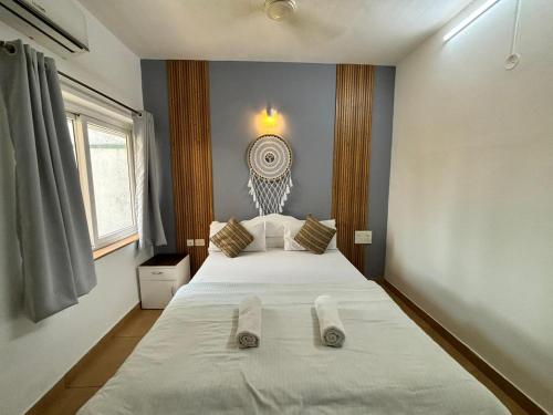 a bedroom with a large bed with two slippers on it at Subtlestays in Arpora
