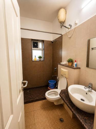 a bathroom with a toilet and a sink at Subtlestays in Arpora