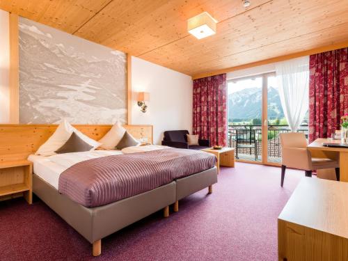 a hotel room with a bed and a balcony at Hotel Goldene Rose in Reutte