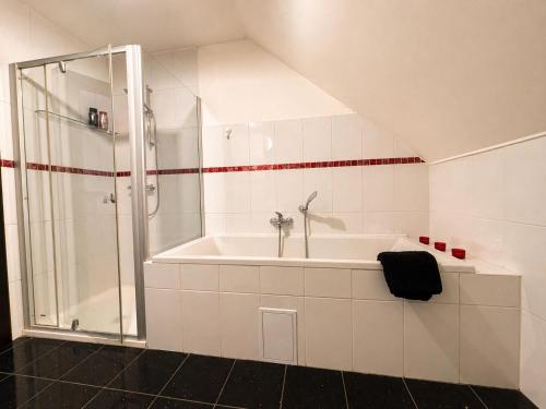a white bathroom with a shower and a tub at Atik V Borovičkách in Lipuvka