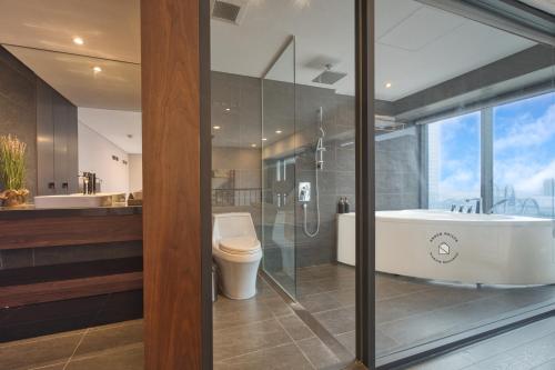a bathroom with a tub and a toilet and a sink at Luxury Duplex & Apartment Pentstudio - Tay Ho Hanoi in Hanoi