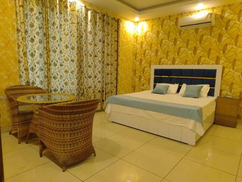 a bedroom with a bed and a table and chairs at Angel Garden Farmhouse in Noida