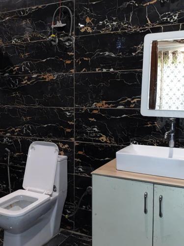 a bathroom with a toilet and a sink at Angel Garden Farmhouse in Noida