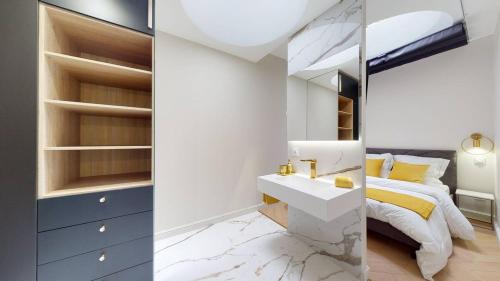 a bedroom with a bed and a sink and a mirror at Le Petit Piron in Dijon