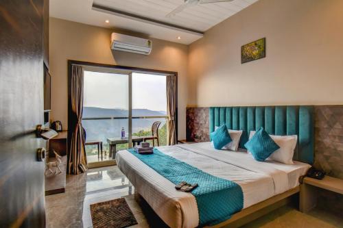 ein Schlafzimmer mit einem Bett und einem großen Fenster in der Unterkunft Holiday Plus in Panchgani