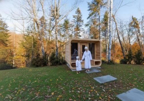 a woman and child standing in front of a tiny house at Spa & Sauna Pool Table & Game Room - Le Perche in Brownsburg