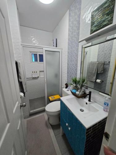 a bathroom with a sink and a toilet and a mirror at The beach house, Baroro Beachfront Villa in Bacnotan
