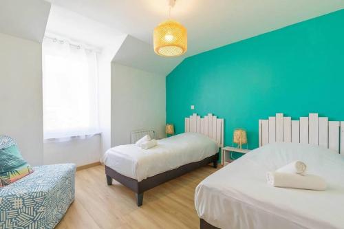 a bedroom with two beds and a blue wall at La Cabotte d'Ahuy in Ahuy