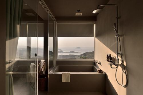 a bathroom with a shower and a sink with a window at Daybreak in Jiufen