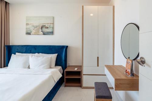 a hotel room with a bed and a mirror at La Living Collection in Ho Chi Minh City
