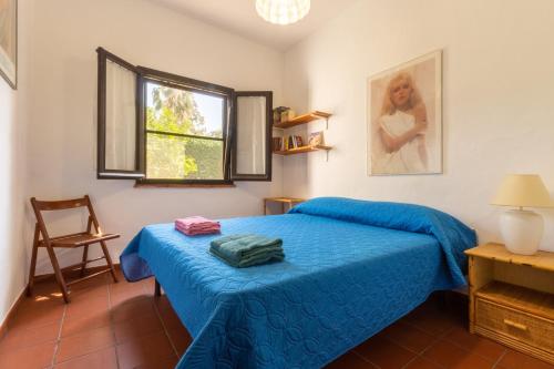 a bedroom with a bed and a chair and a window at Villa Terry in Marongiu