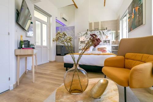 a living room with a vase with flowers on a table at Le Relax SPA in Dijon