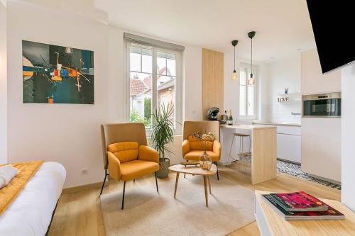 a living room with a couch and chairs and a kitchen at Le Relax SPA in Dijon