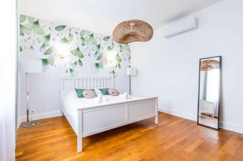 a bedroom with a white bed and a mirror at La Balzac in Dijon