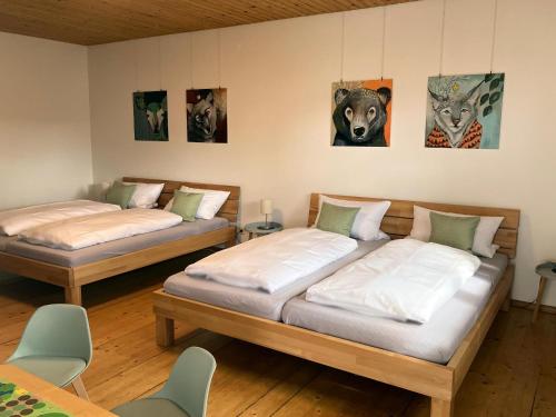 two beds in a room with paintings on the wall at Ferienhaus Kirchl in Hohenau