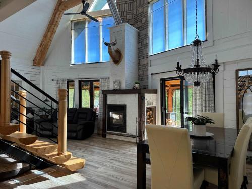 a living room with a table and a fireplace at Spa Swimming Pool & Nature - Chalet rang 3 in Roberval
