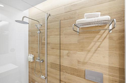 a shower in a bathroom with a wooden wall at B&B HOTEL Cieza in Cieza