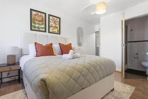 a bedroom with a large bed and a bathroom at The Forest- Fernwood in Cambridge