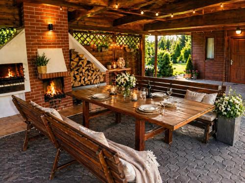 a patio with a wooden table and a fireplace at Argentum Luxury Bungalov in Gąbin