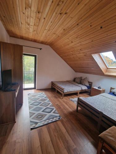 a room with a bed and a couch and a television at Wild River Cottage in Lissa