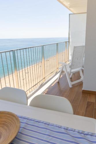a balcony with a table and chairs and the beach at Pis Embaixador - 1a línea de mar in Platja d'Aro