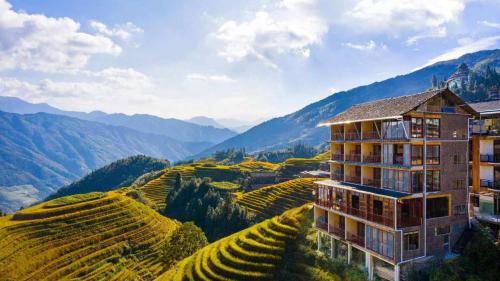 a hotel on a hill next to a vineyard at Longji Forest Lodge--Terraced landscape from the room, Pick-up and drop-off service from Ping'an Village Parking Lot, Sunrise& Sunset in Heping
