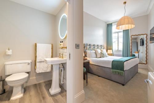 a bedroom with a bed and a sink and a toilet at Crescent Inn by Maison Pierre in Ilkley