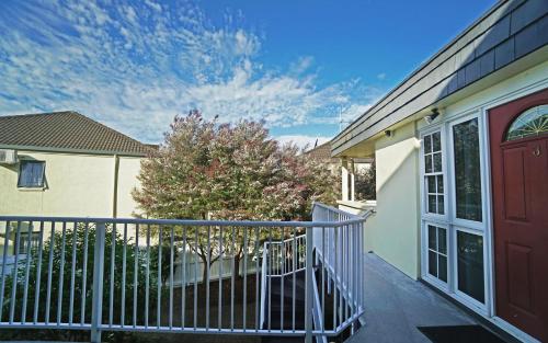 a balcony of a house with a gate and a tree at Anglesea Motel and Conference Centre in Hamilton