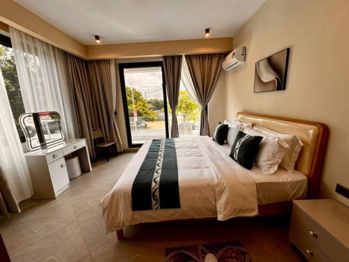 a bedroom with a large bed with a large window at Masaki Cozy Stay in Dar es Salaam