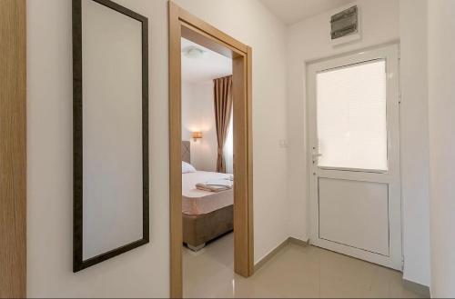 a mirror in a room with a bed and a window at Apartmani Coka in Sušćepan