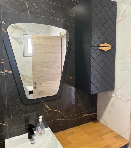 a bathroom with a mirror and a sink at Apartmani Coka in Sušćepan