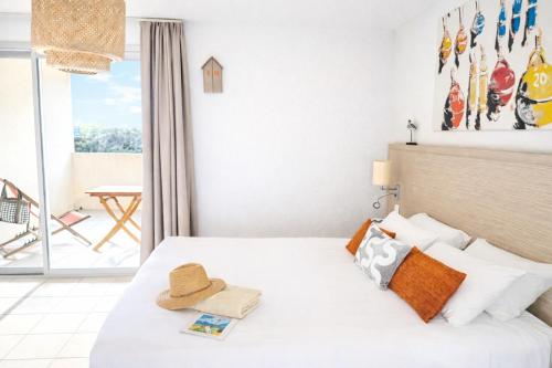a hotel room with a bed with a hat on it at Hotel L'Oceane in La Cotinière