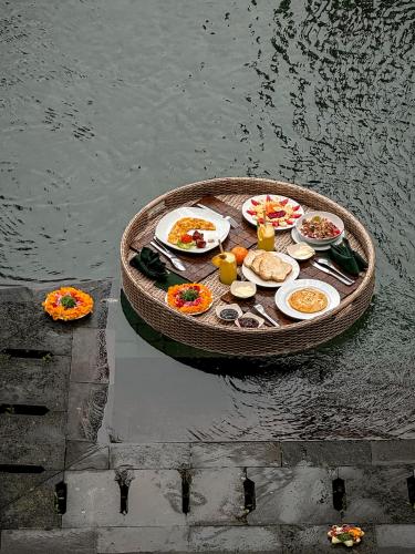 a table of food in a small boat in the water at Villa Kalisha - Romantic, Seclusion in the heart of Nature in Tegalalang