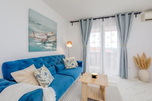 a living room with a blue couch and a table at Apartments Mare in Punat