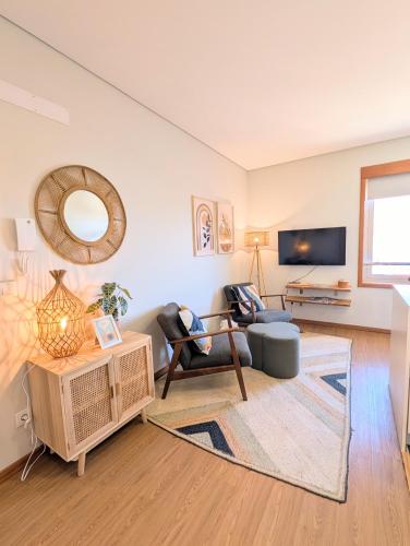 a living room with a couch and a tv at 3E Apartamento encantador a 3 minutos da praia in Matosinhos