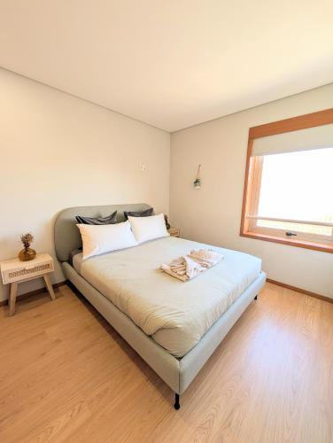 a bedroom with a large bed with a window at 3E Apartamento encantador a 3 minutos da praia in Matosinhos