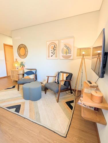 a living room with a couch and a tv at 3E Apartamento encantador a 3 minutos da praia in Matosinhos