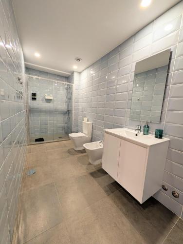 a bathroom with a toilet and a sink and a mirror at 3E Apartamento encantador a 3 minutos da praia in Matosinhos