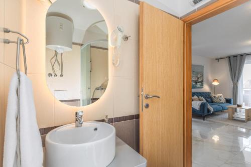a bathroom with a sink and a mirror at Apartments Mare in Punat